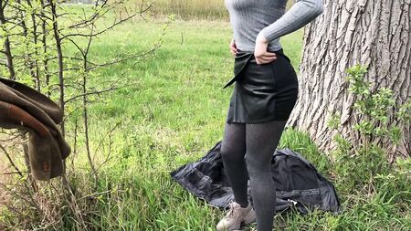 Una ragazza in pantaloncini di pelle sexy fa un pompino all'aperto e ingoia lo sperma