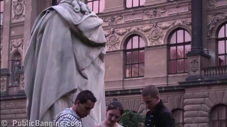 Una ragazza adolescente carina che scopa in PIAZZA, vicino a una famosa statua