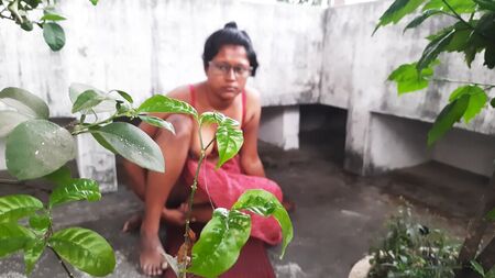Una donna bengalese in sari scopata all'aperto