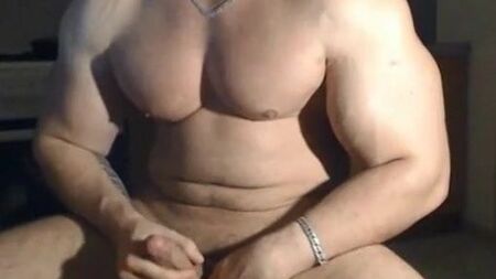 Un uomo molto attraente e muscoloso che posa e si masturba