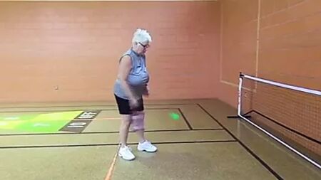 Una donna matura senza reggiseno con enormi tette cadenti che gioca a pickleball