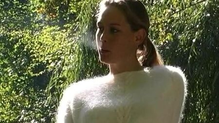Una signora con un maglione morbido fuma
