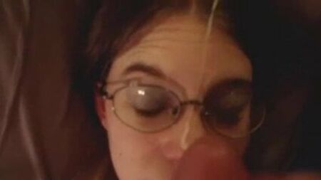 Ragazza bruna un po' nerd con gli occhiali che riceve una bella sborrata in faccia, in POV