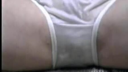 Una ragazza carina che ride in mutandine di nylon bianche