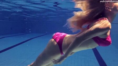La bellezza nuda nuota in piscina