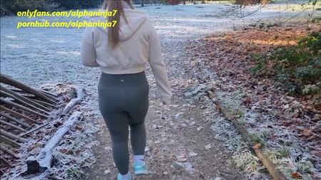 Donna adulta in pantaloni attillati scopa in bocca nel parco