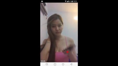 Una donna vietnamita si stringe il seno e lo mostra davanti alla telecamera