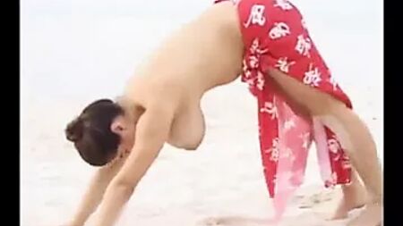 Una ragazza con un seno prosperoso si distende sulla spiaggia